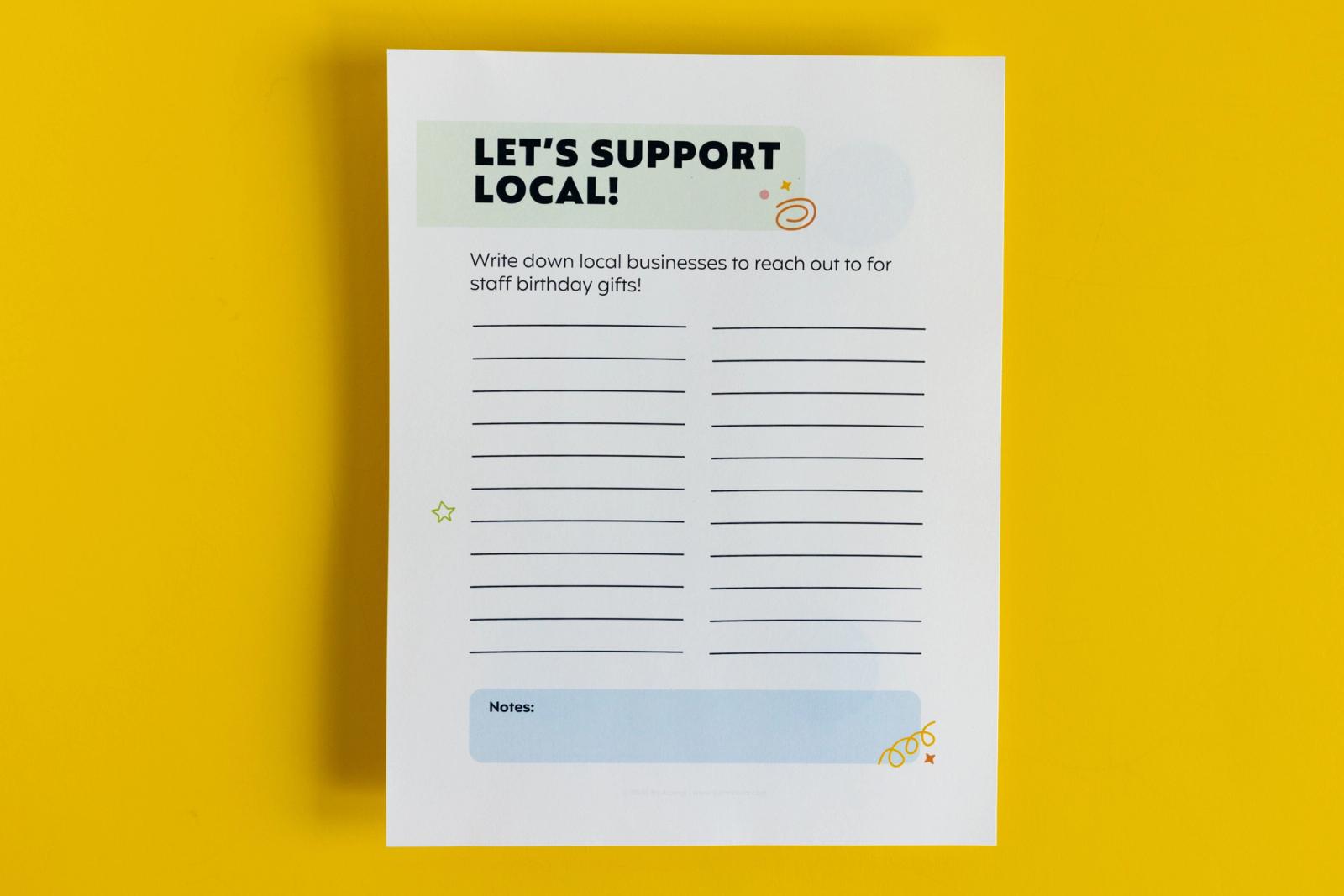 A piece of paper that says "let's support local" lay on a yellow background.