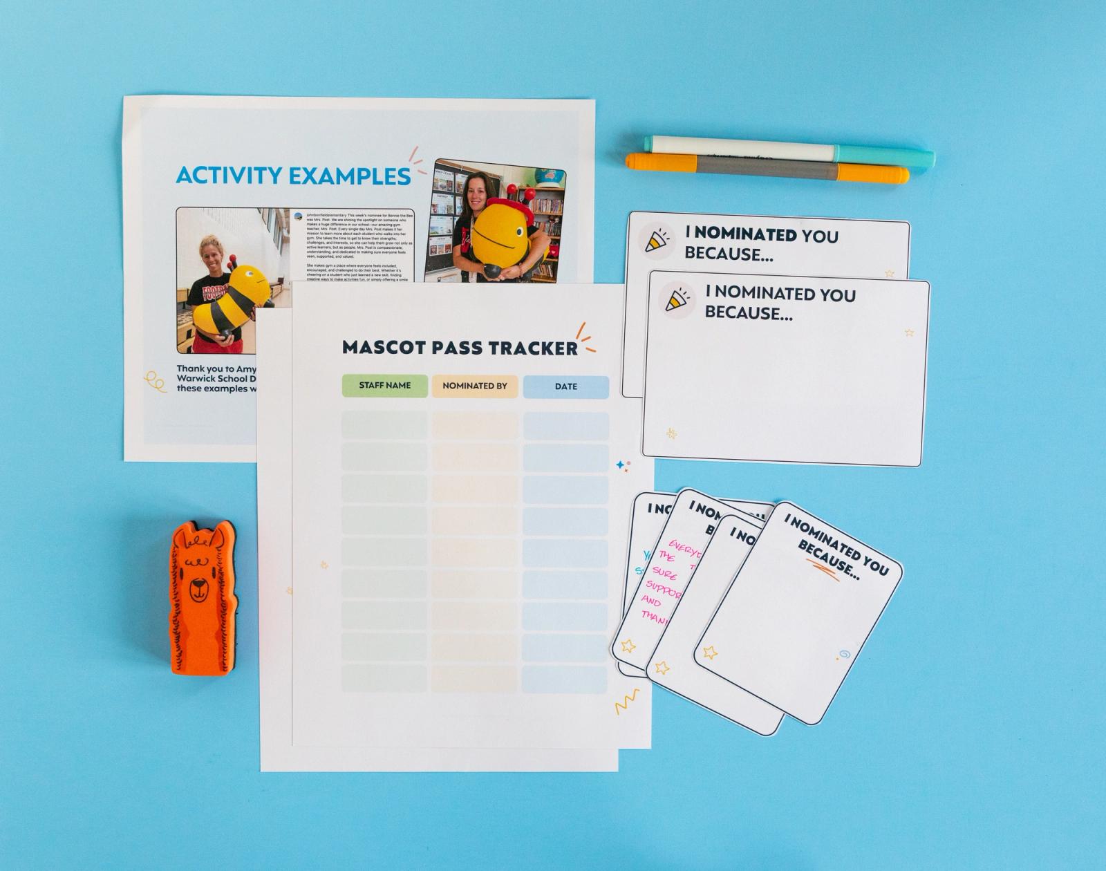 Several sheets of paper, notecards, and pens lay on a light blue background.