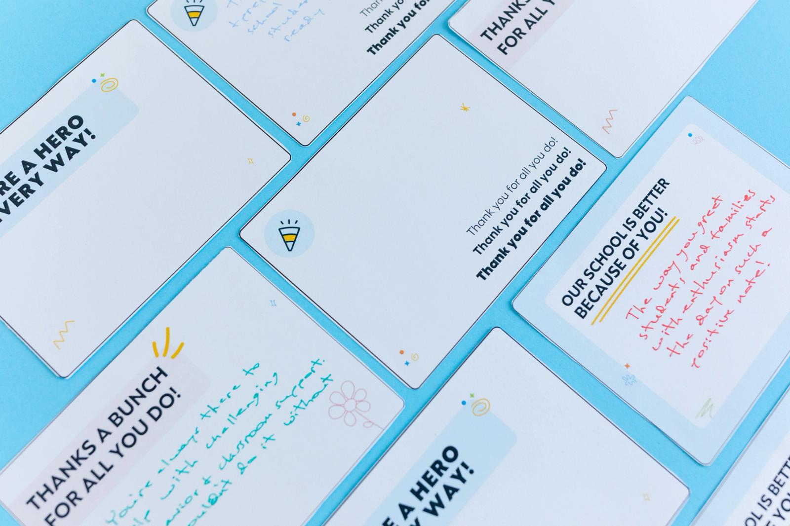 Notecards with handwritten notes on them lay diagonally on a light blue background.