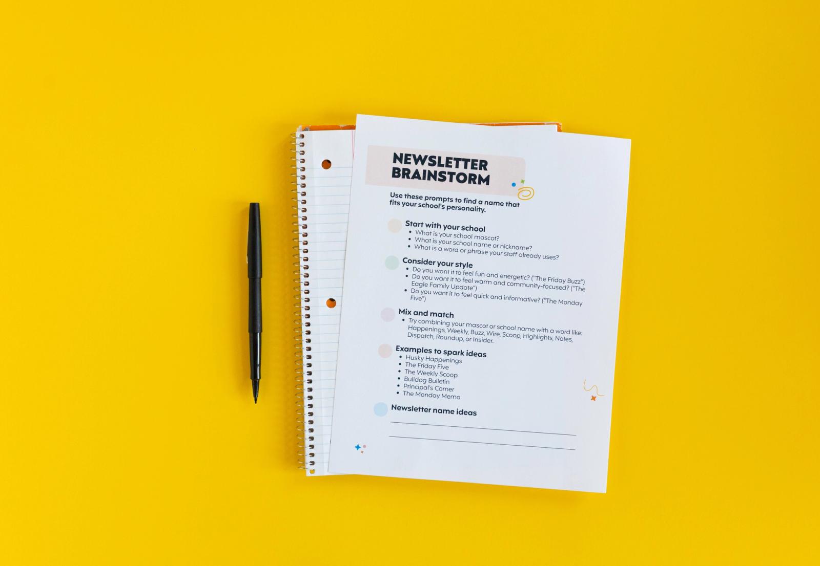 White paper and spiral notebook with black pen on yellow background