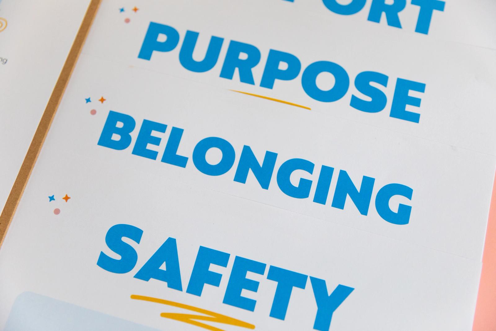 Close up of three posters that say purpose, belonging, and safety on them. 