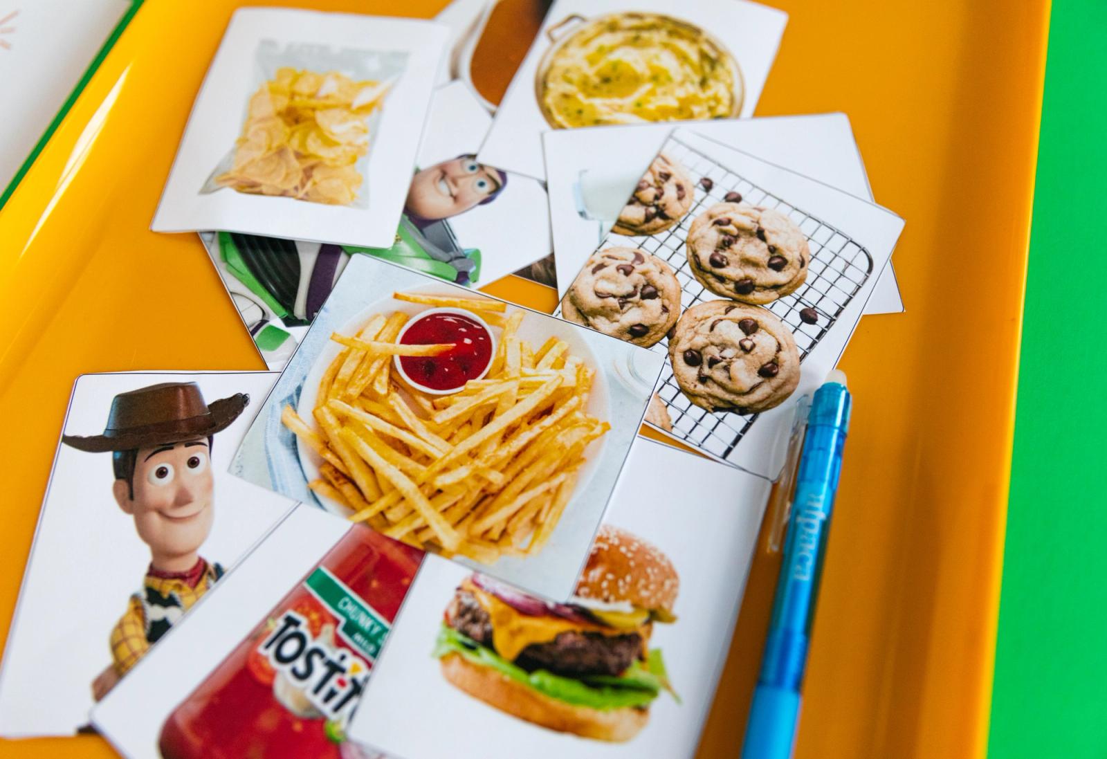 Closeup of printed images on paper laying in an orange tray on a green background.