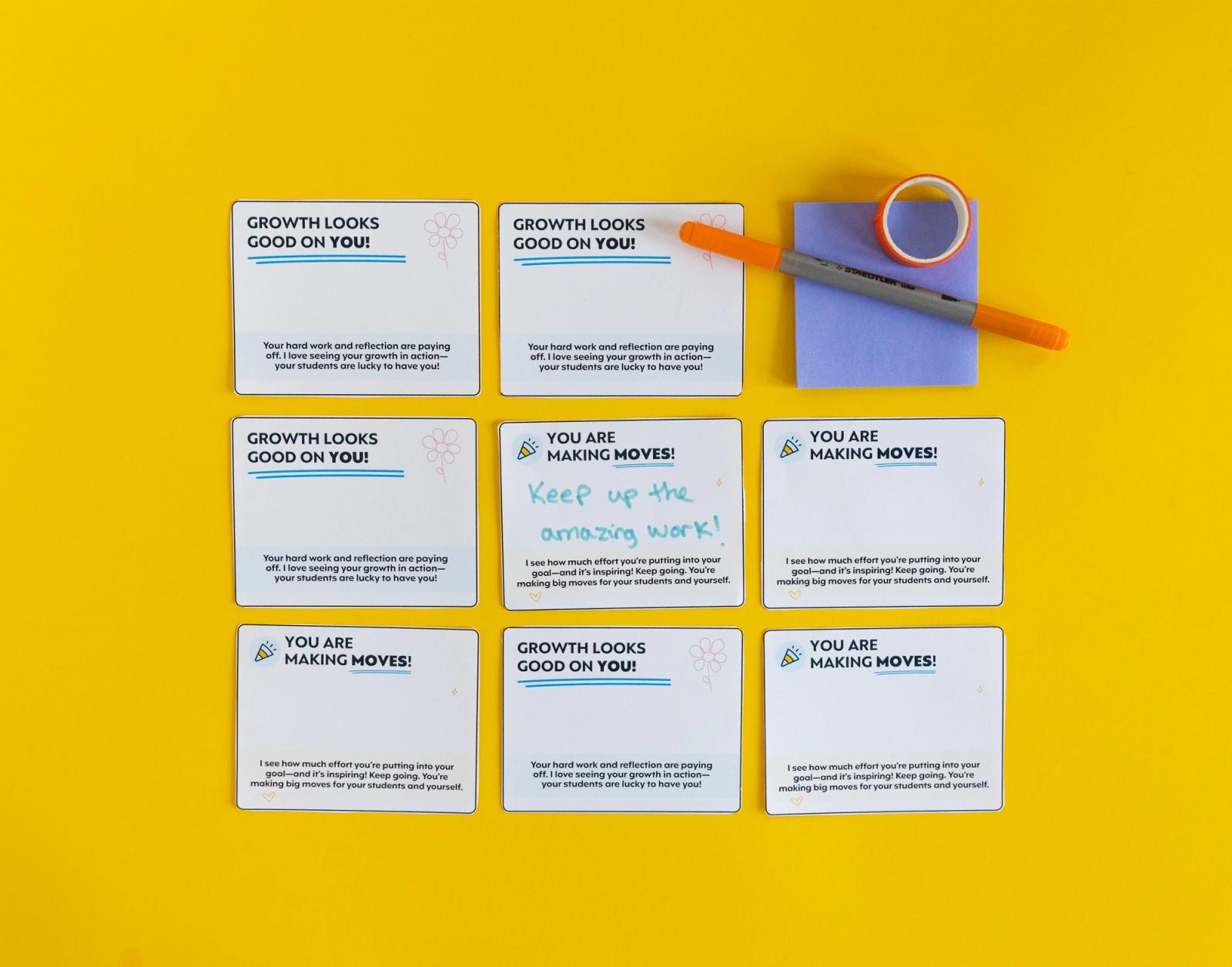 Eight notecards, a purple sticky note pad, orange pen, and roll of tape lay on a yellow background.