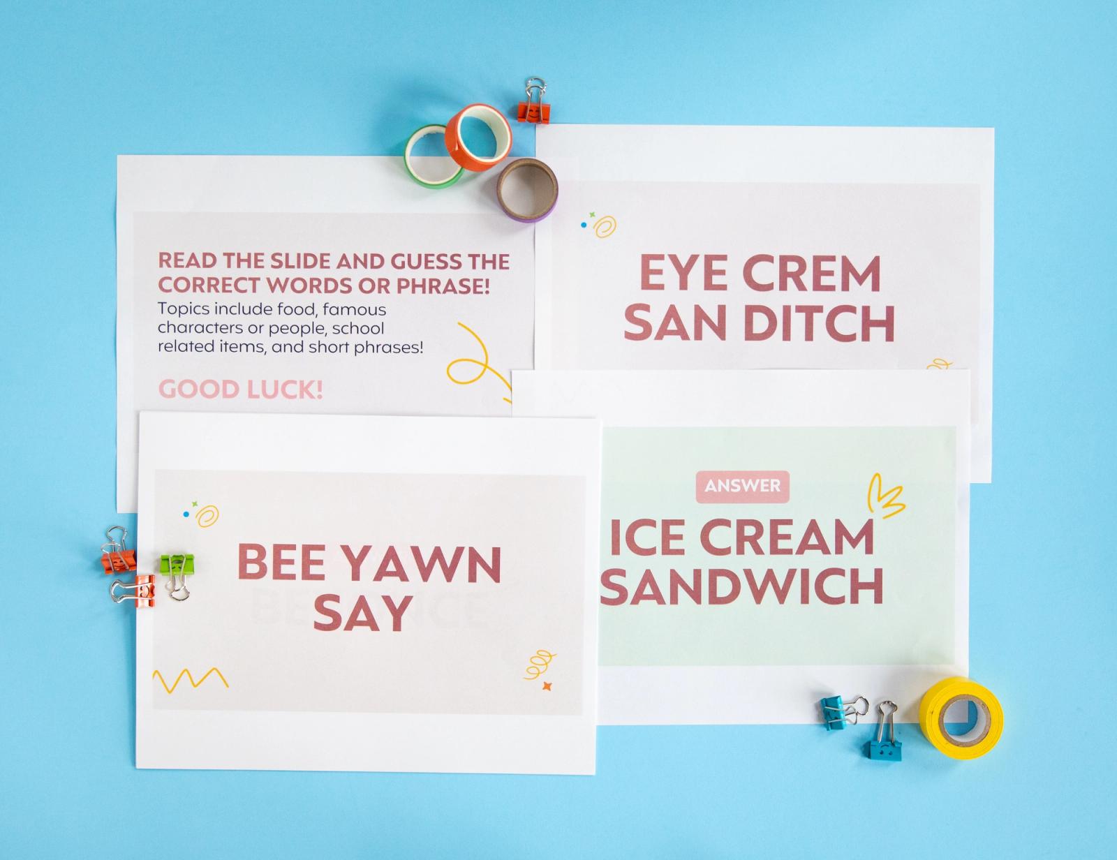 Four sheets of paper, rolls of tape, and paper clips lay on a light blue background.