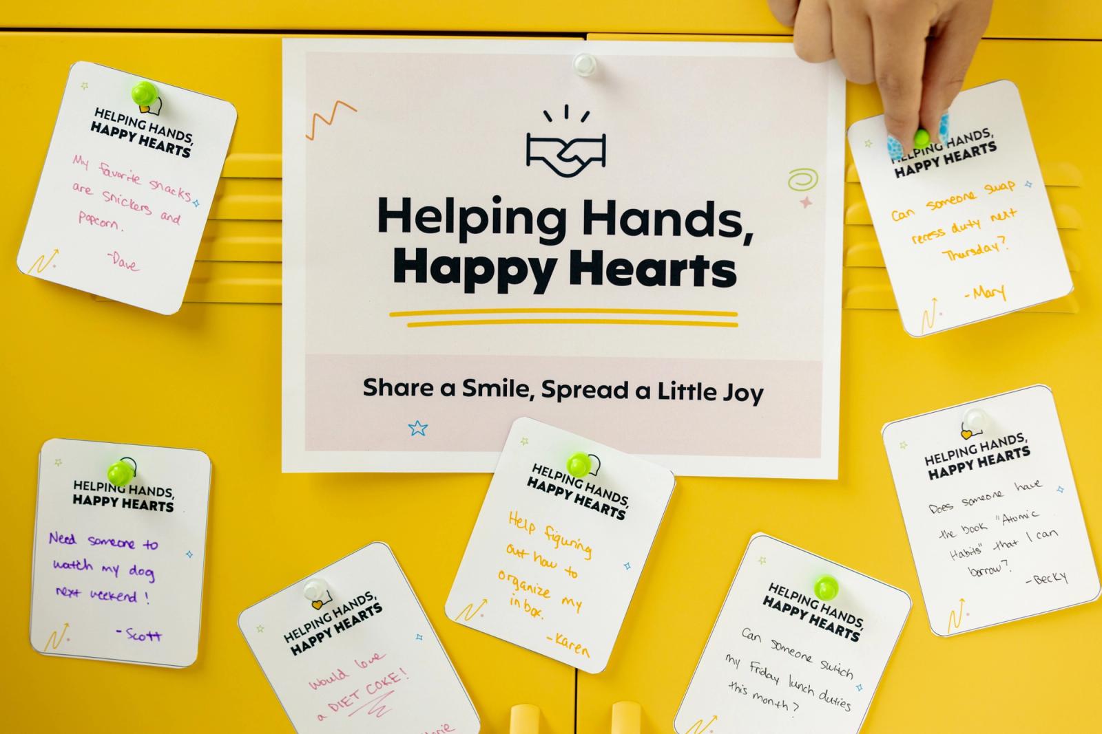 A poster that says "helping hands, happy hearts" is taped to yellow lockers. Around it are small notes and a hand reaches in to place another note.
