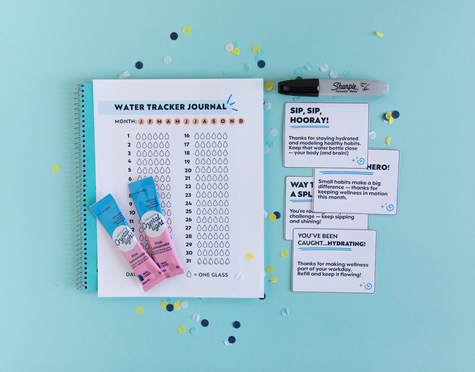 A sheet of paper on a blue notebook and drink flavor packets lay on a light blue background. Beside them are cards and a black marker. Confetti surrounds them.