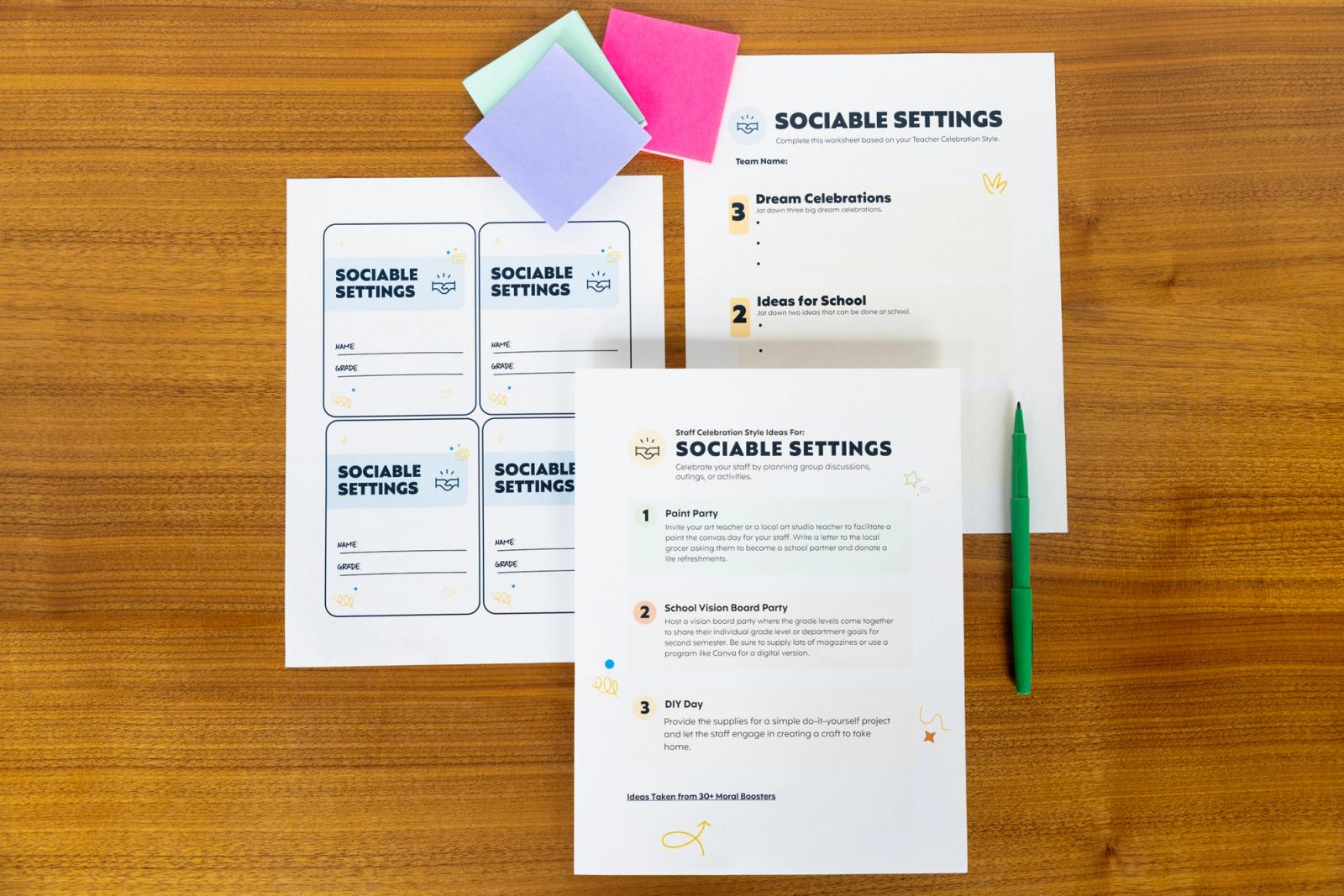 Three sheets of paper that say "sociable settings," pens, and sticky notes lay on a table.