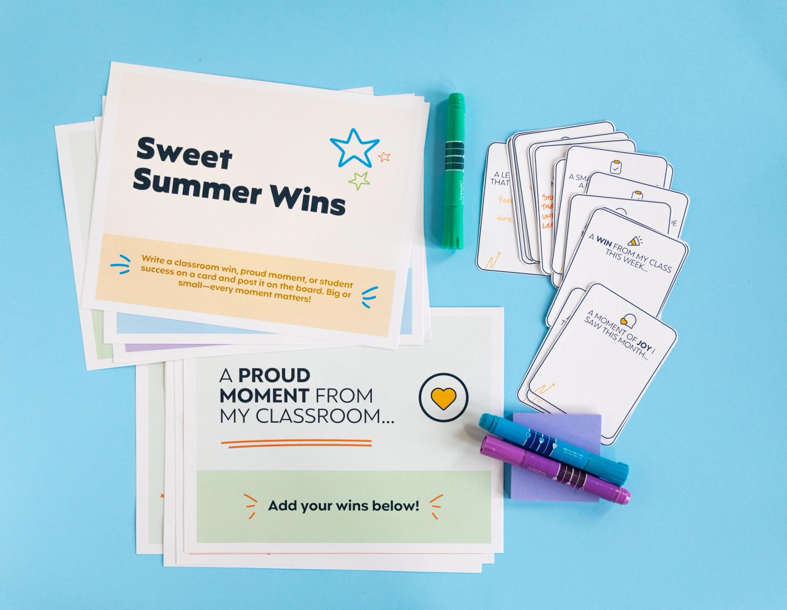 Posters, small notecards, and markers lay on a light blue background.