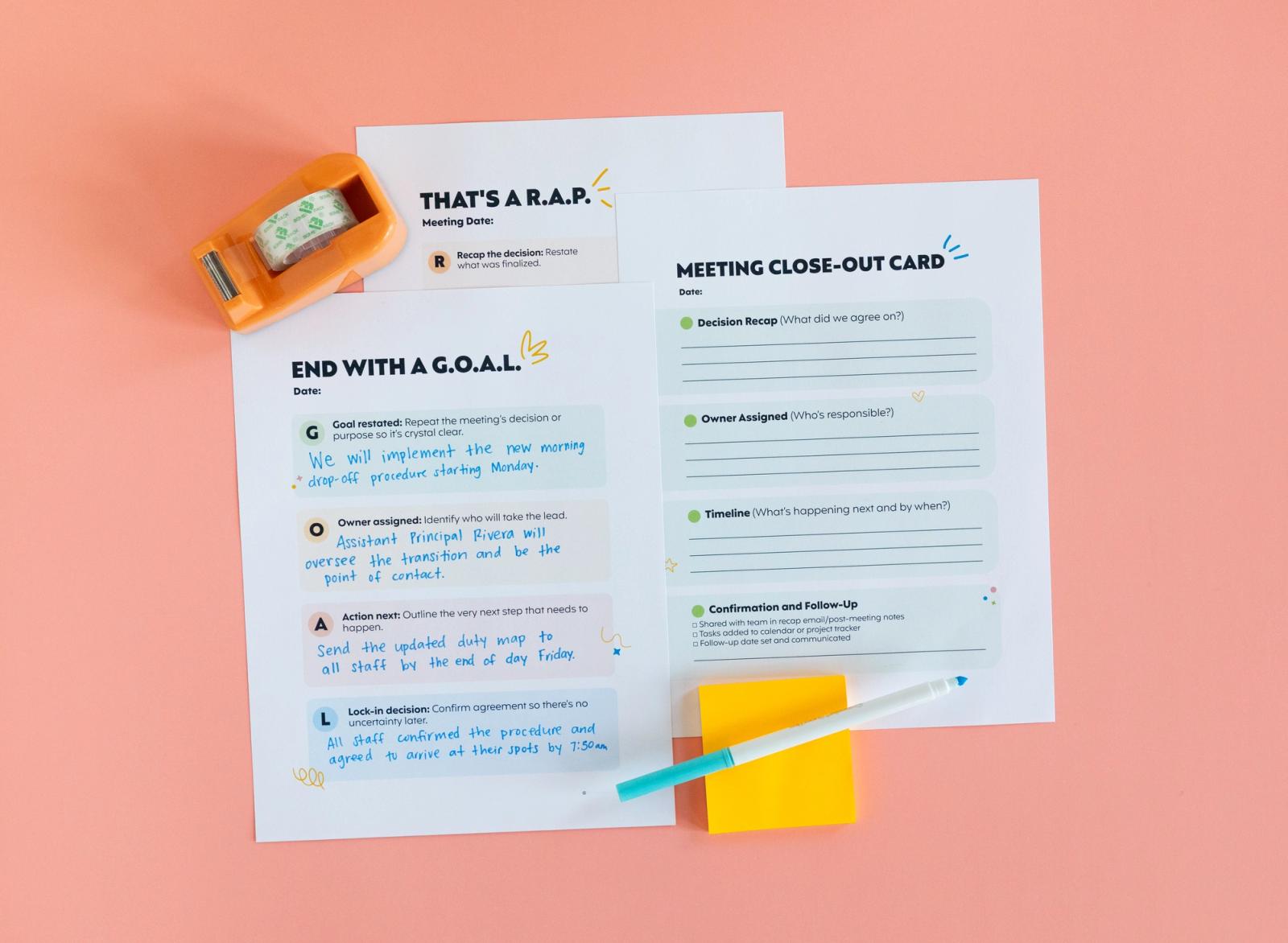 Three pieces of paper with writing on them, yellow post-it notes, blue marker, and tape dispenser on a peach background.