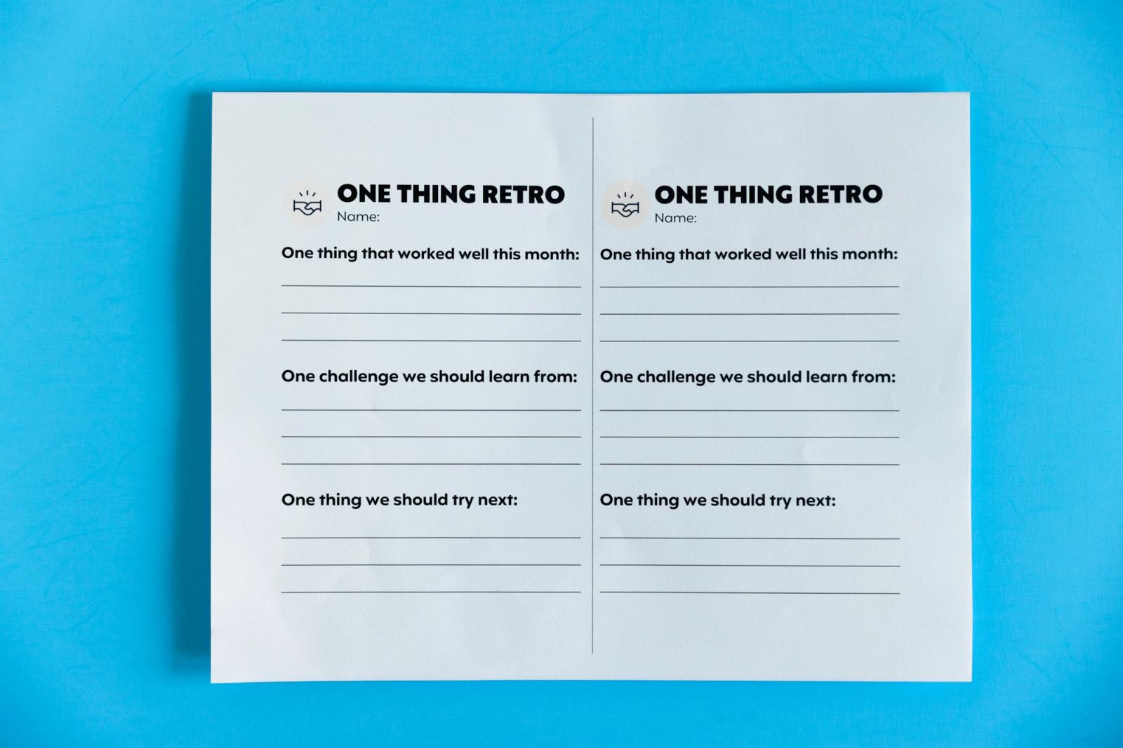 A sheet of paper that says "one thing retro" lays on a light blue background.