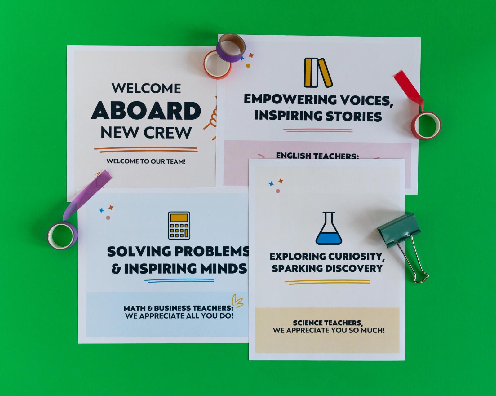 Four posters lay on a green background surrounded by rolls of tape and paper clips.