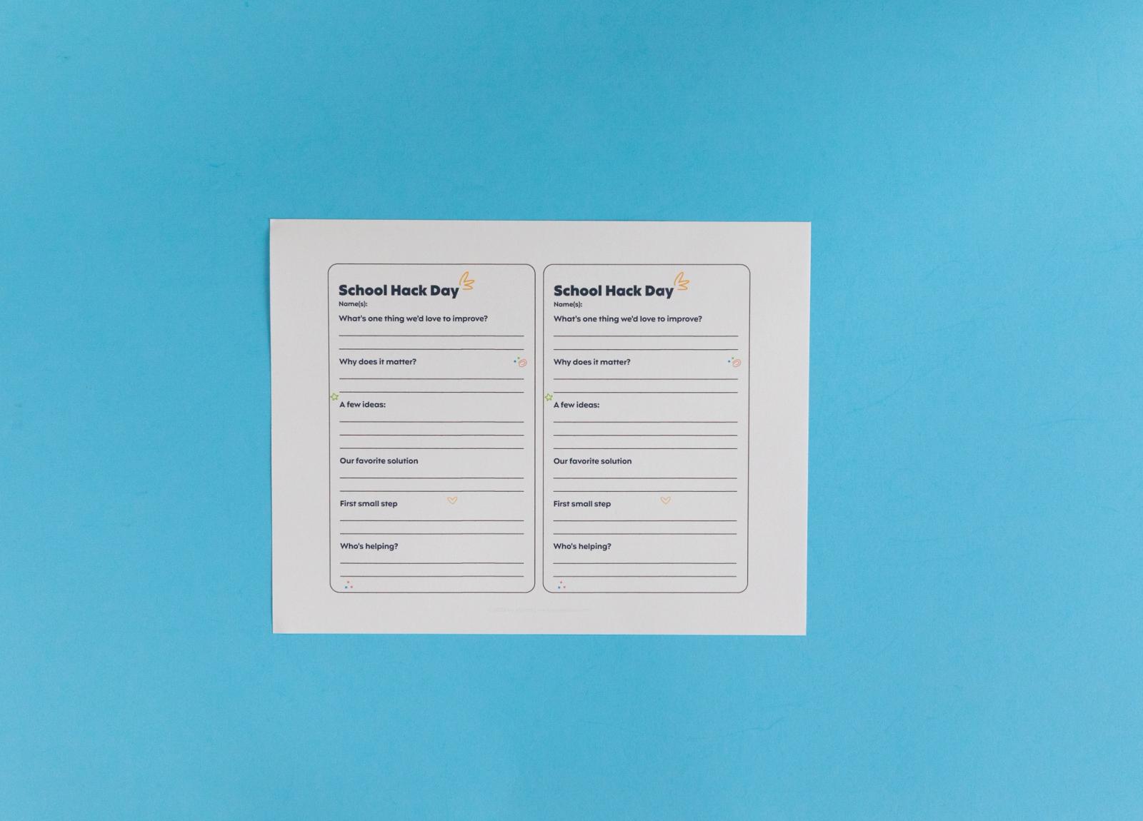 Sheet of paper with notecards that say "school hack day" lays on a light blue background.