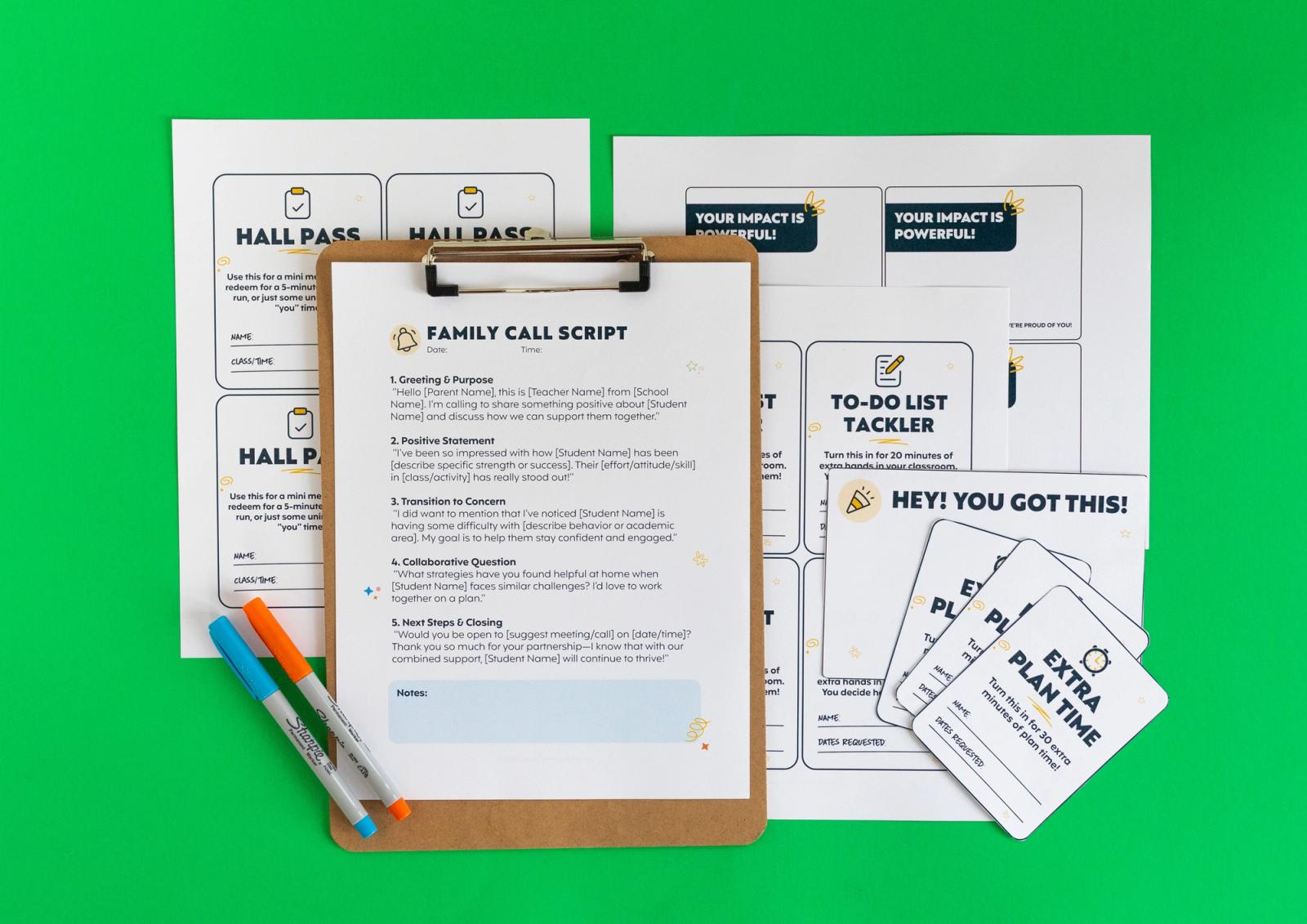 Sheets of paper, notecards, pens, and a clipboard with a piece of paper on it lay on a green background.