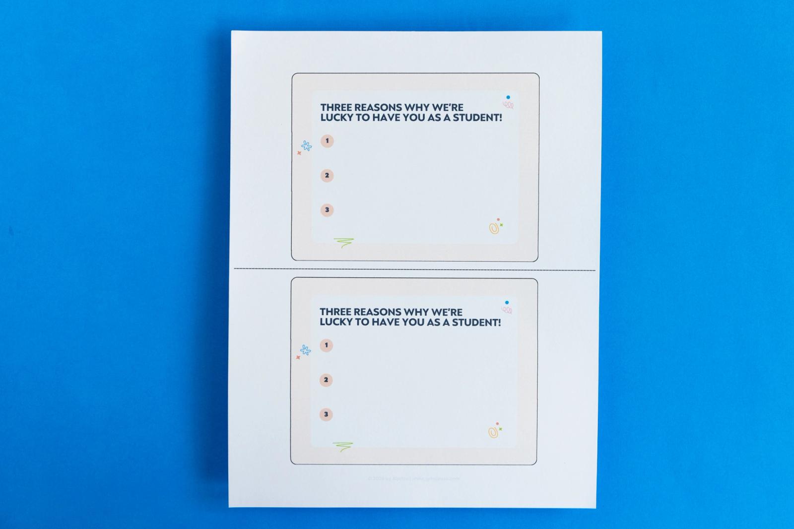 A piece of paper that has two notecards on it that say "three reasons why we're lucky to have you as a student" lay on a blue background.