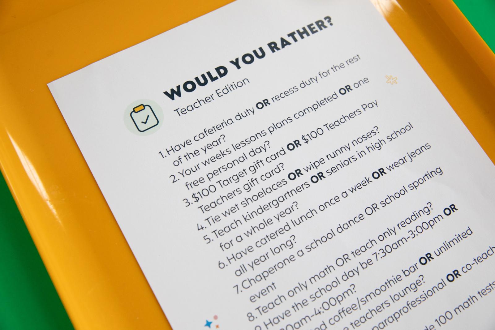A sheet of paper that says "would you rather" lays on an orange tray. 