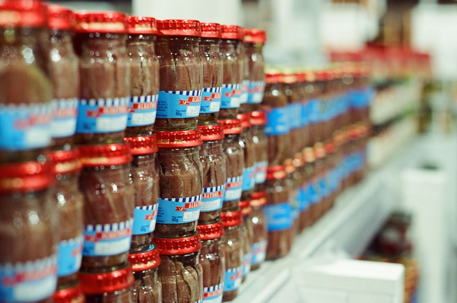 Rows of small bottles with brown liquid on a shelf, photo by Barney Goodman on Unsplash