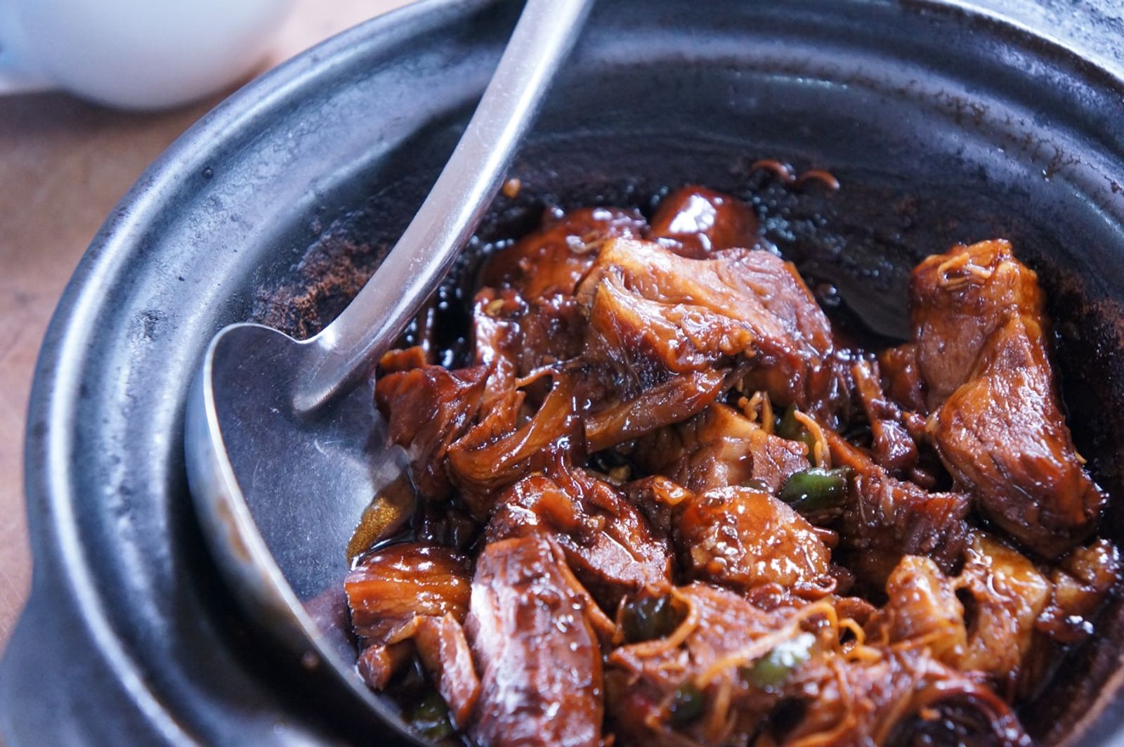 A cast iron pot of slow braised beef and vegetables in rich broth, steam rising on a cold day, photo by yvonne lee harijanto on Unsplash