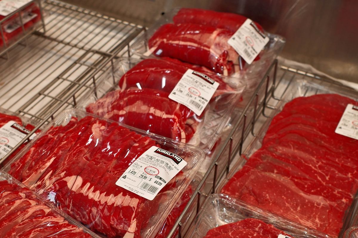 A butcher counter glass case filled with labelled cuts of fresh meat arranged in neat rows, photo by 0xk on Unsplash