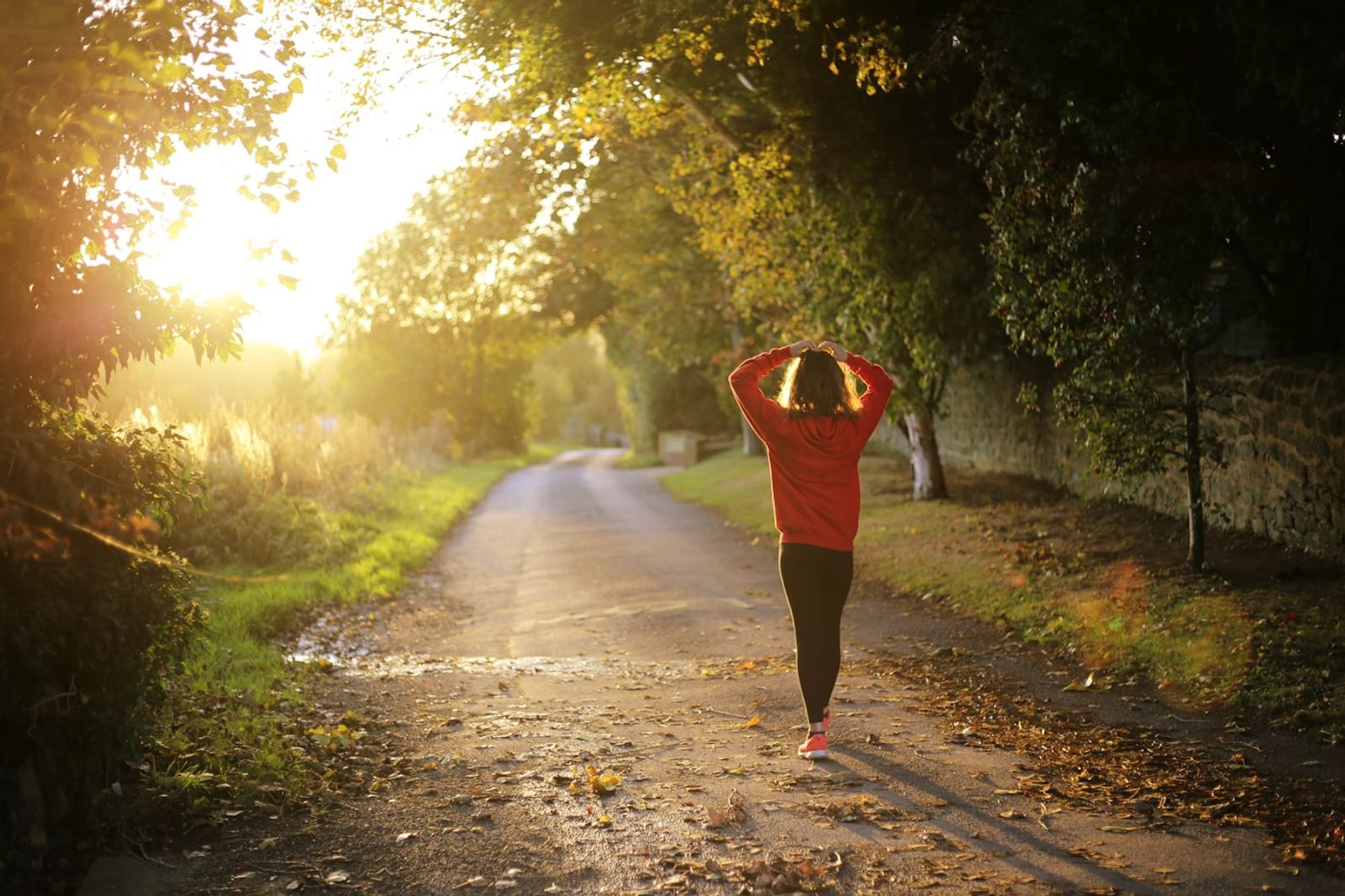 A person in casual activewear walking briskly along a suburban street in the morning light, photo by Emma Simpson on Unsplash