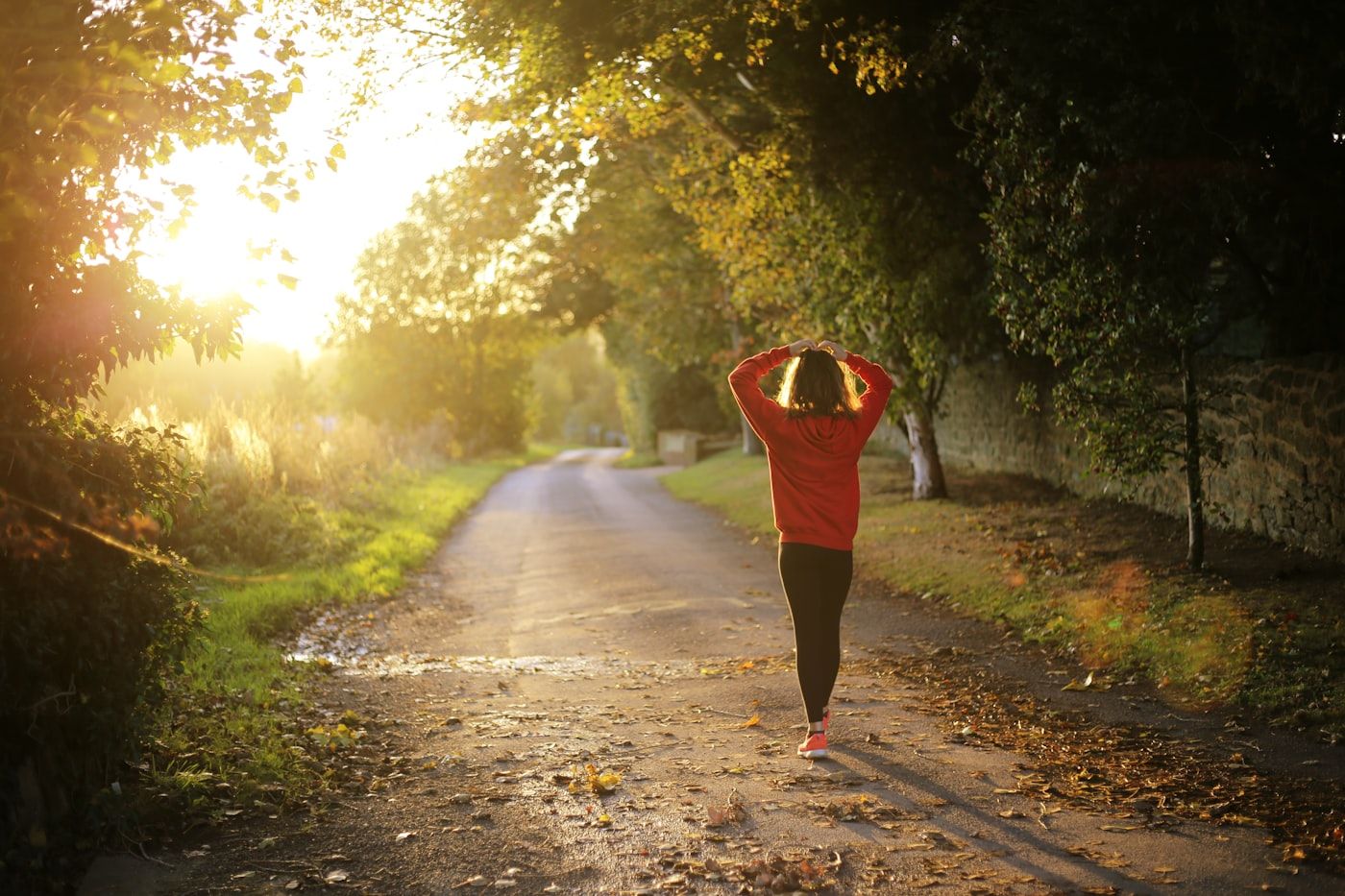 A person in casual activewear walking briskly along a suburban street in the morning light, photo by Emma Simpson on Unsplash