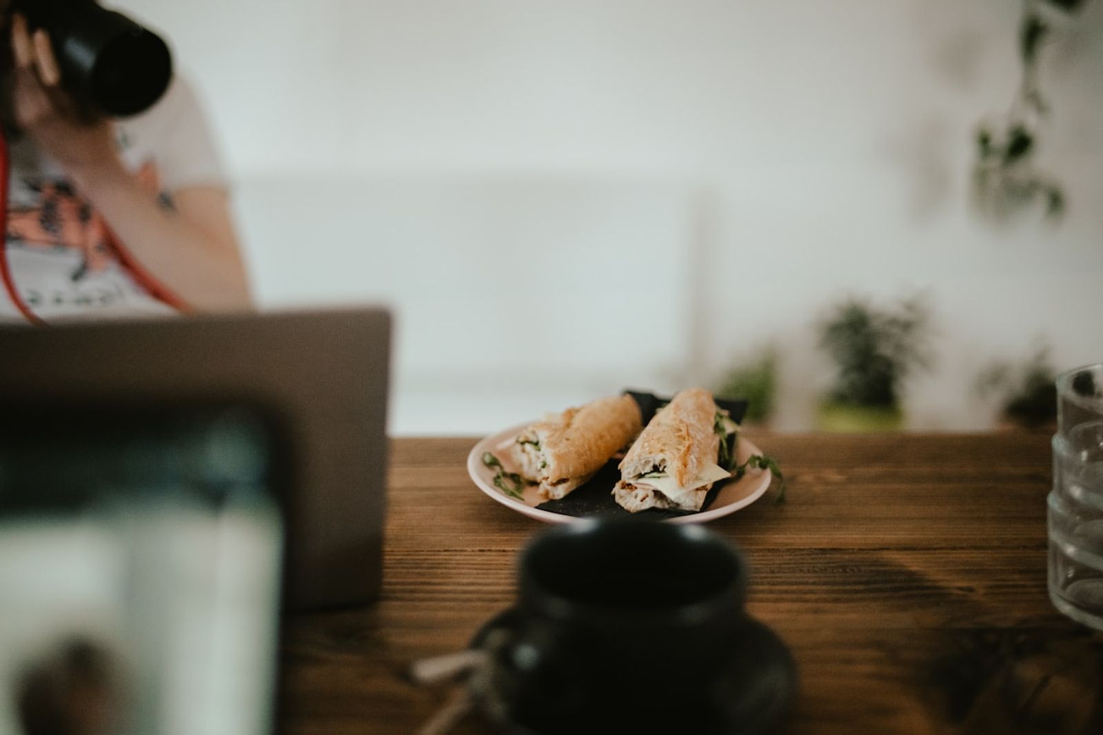 A person eating a simple meal at a cluttered desk between tasks during a busy workday, photo by Annie Spratt on Unsplash