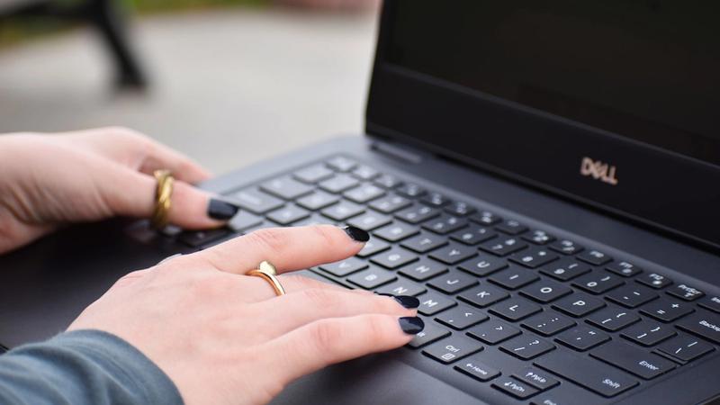 Business owner typing on a laptop while drafting an AI prompt