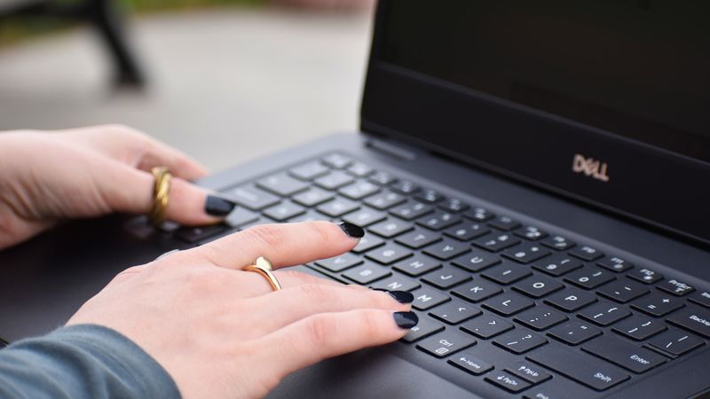 Business owner typing on a laptop while drafting an AI prompt