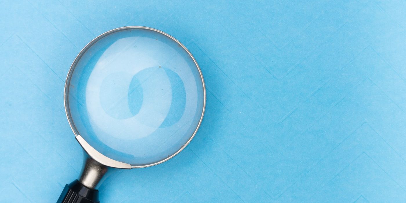 Magnifying glass reviewing printed documents
