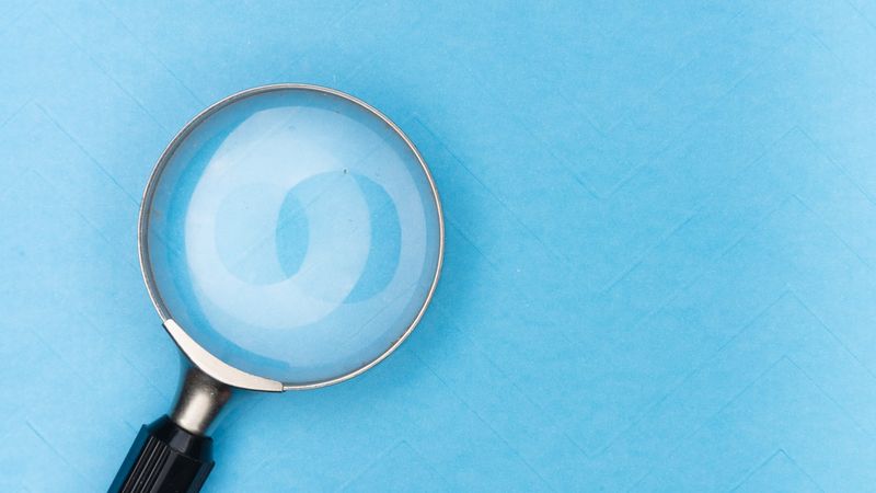 Magnifying glass reviewing printed documents