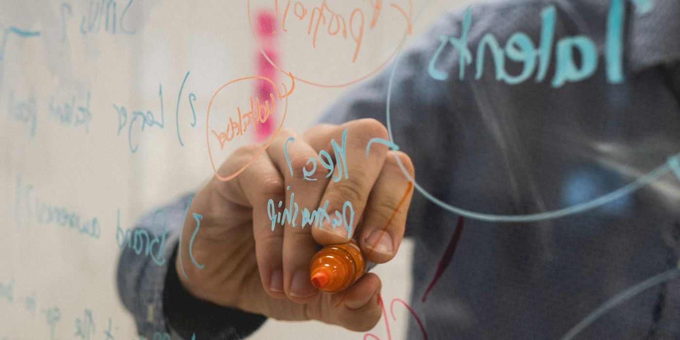 Person mapping out a plan on a glass whiteboard — building a 90-day AI roadmap