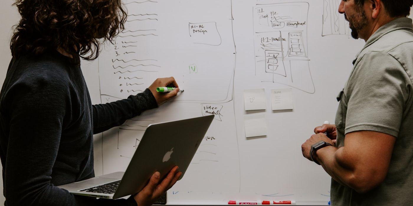 Manager briefing a team at a whiteboard