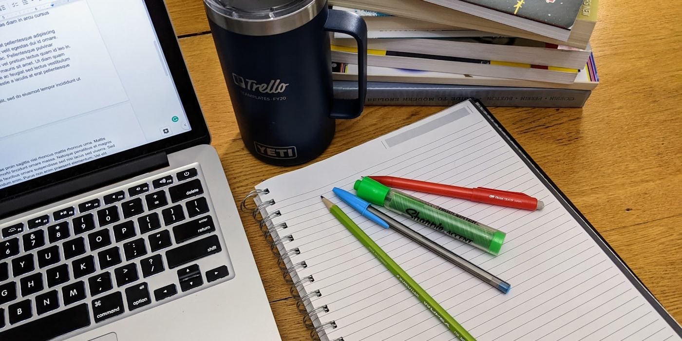 Open notebook with pen and highlighters on a wooden desk — building a brand voice document