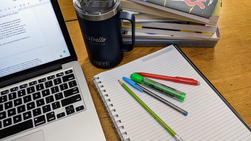 Open notebook with pen and highlighters on a wooden desk — building a brand voice document