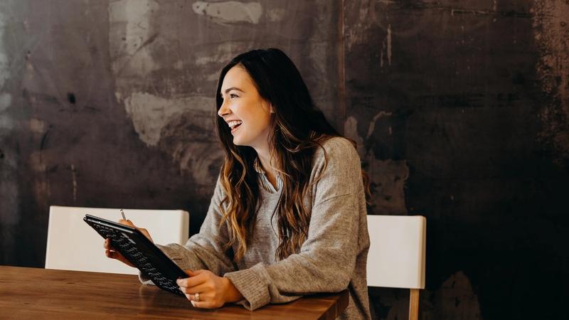 A business owner sits at a desk studying a spreadsheet of costs alongside a laptop, weighing up a technology decision, photo by Brooke Cagle on Unsplash