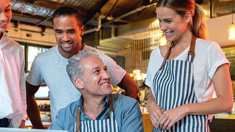 Business owner reviewing AI adoption data on a laptop in a modern Australian office