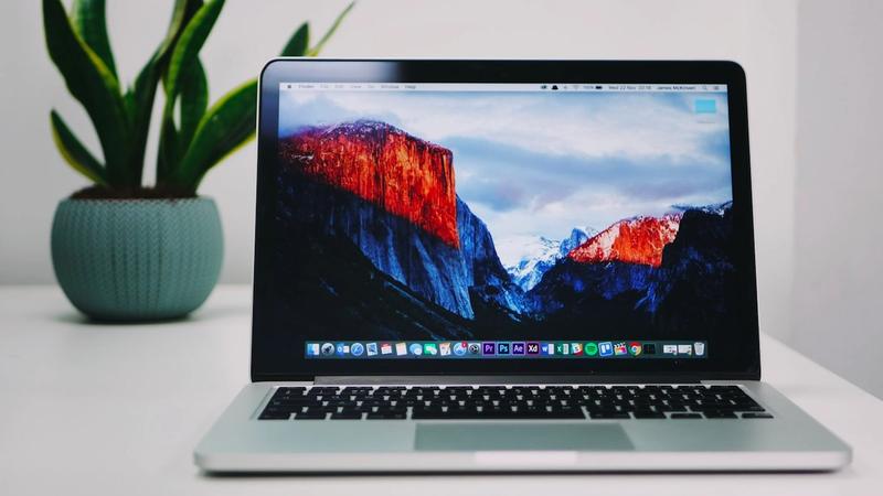 A desk with a laptop and coffee — reviewing software subscriptions and AI tool spend