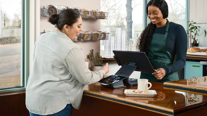 Customer pays cashier at a counter in a shop., photo by SpotOn on Unsplash