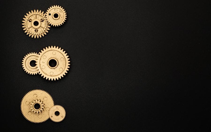 Brass clockwork gears arranged on a black surface