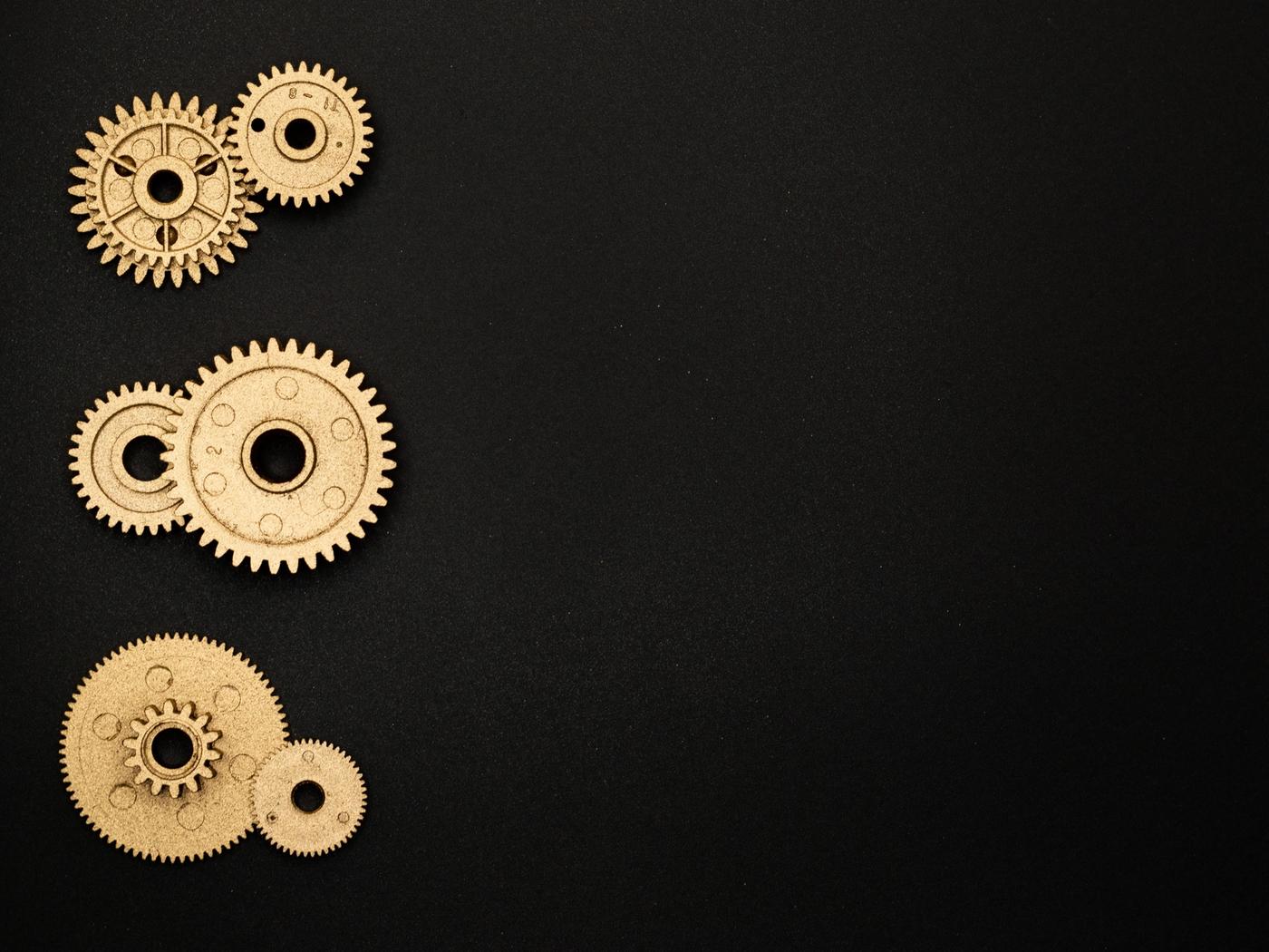 Brass clockwork gears arranged on a black surface