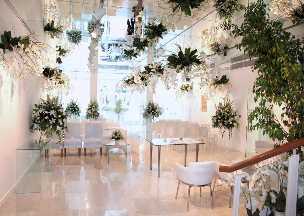 The Mawar Gallery dressed with tall floral arrangements and hanging greenery for a reception