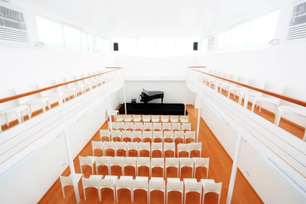 Theatre seating facing the grand piano in the Melati Hall, seen from the mezzanine balcony
