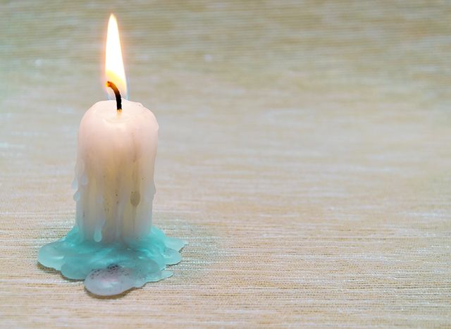 table with a burning candle on it.