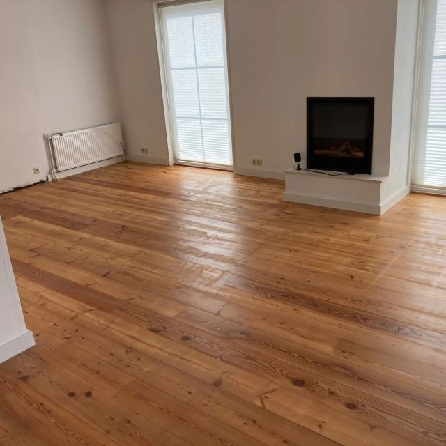 Grenen vloer in een lichte kamer met haard, behandeld met Osmo Hardwaxolie Original 3032, Kleurloos zijde-mat