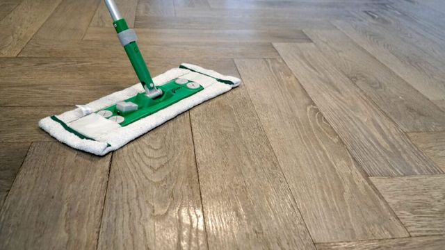 Houten vloer die met een vlakmop wordt gereinigd