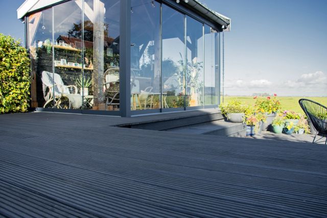 Vlonderterras met glazen pui en uitzicht op de tuin