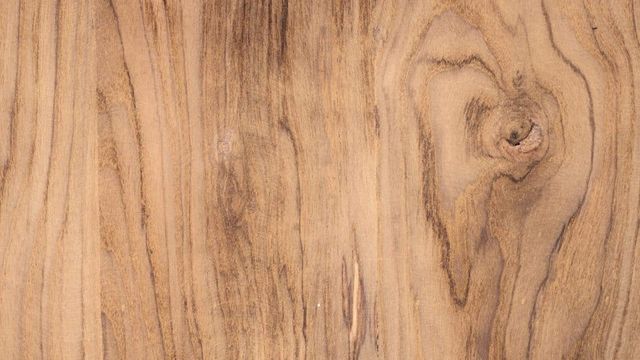 Close-up van teakhout met warme nerf en een noest