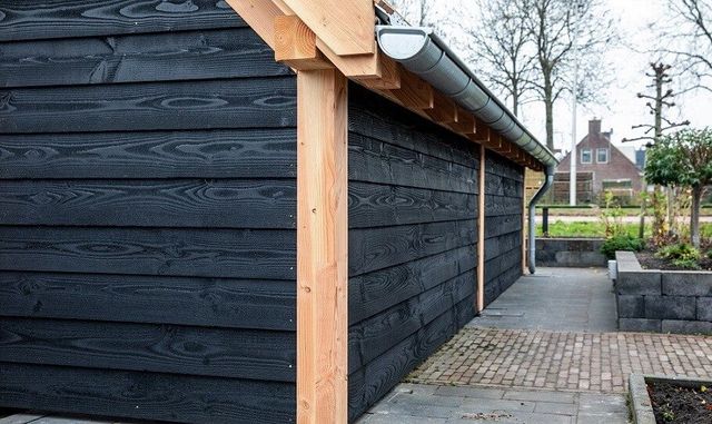 Wooden garden shed with black planks