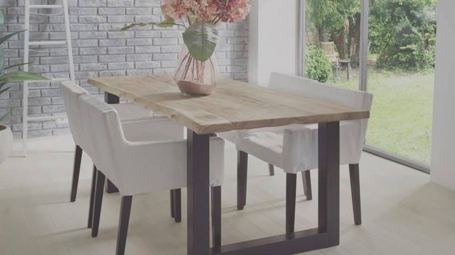 Eettafel met licht houten blad en grijze stoelen bij een raam