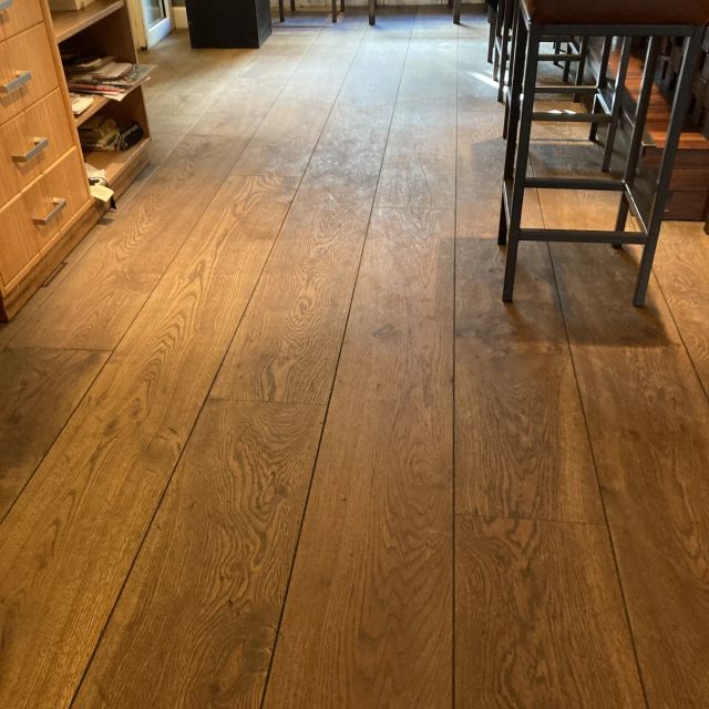 Eiken horecavloer langs de bar met krukken, behandeld met Osmo Hardwax-Olie Farbig 3073, Terra