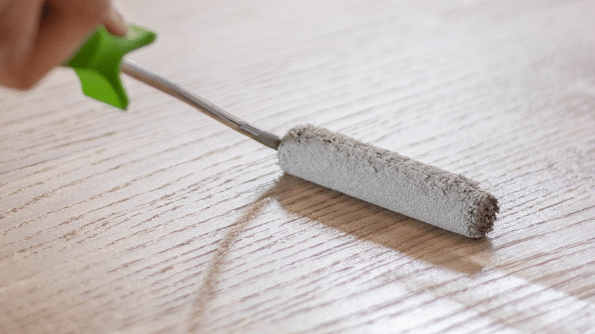 Persoon brengt olie aan op tafel